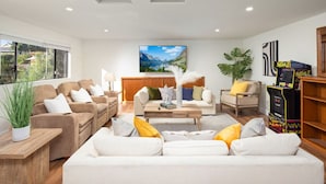 A modern living room with a sofa set, a coffee table, and a gaming console. - Elegant City View | Quick Drive to LA | Hot Tub (La Crescenta-Montrose)