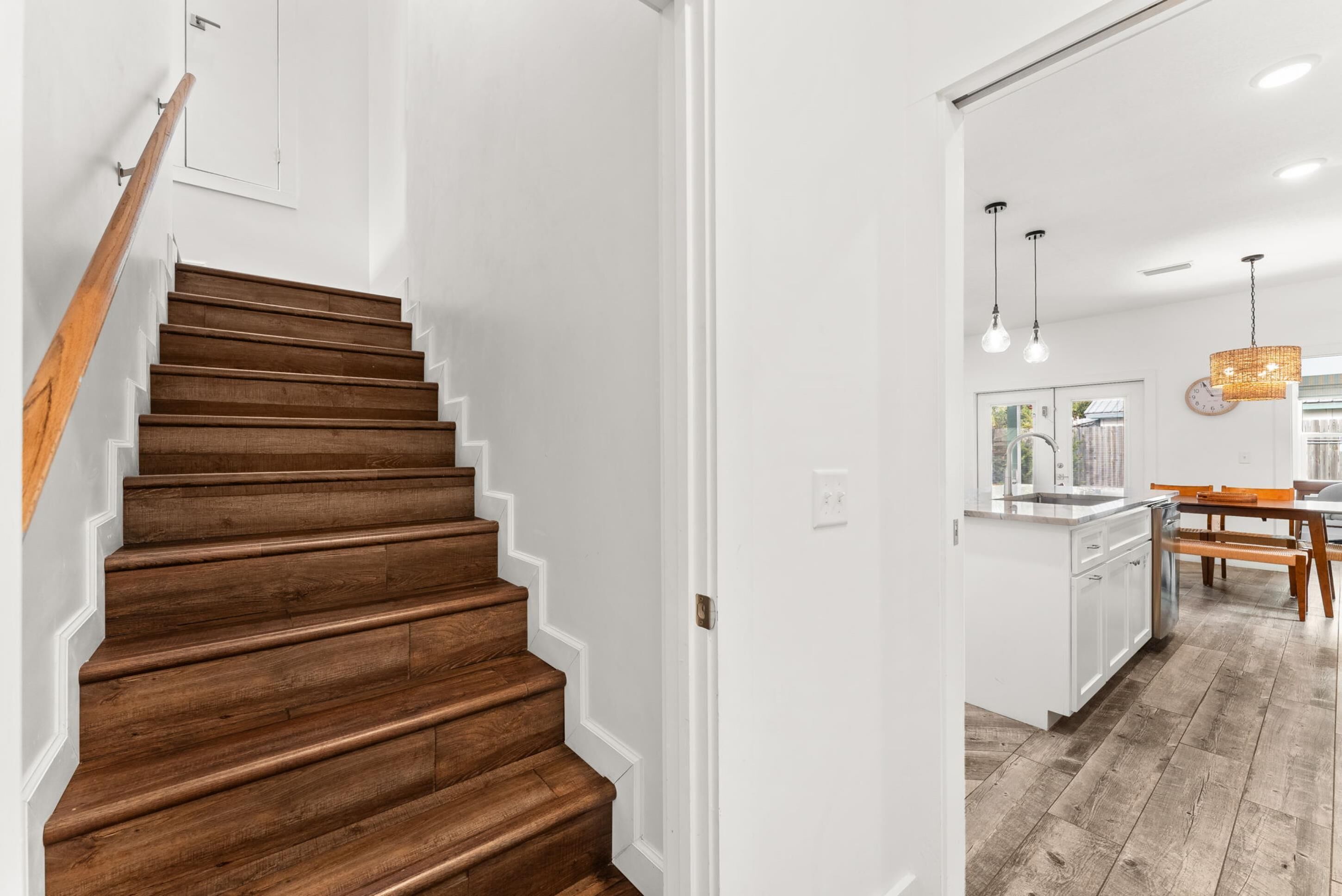 A staircase with wooden steps leading to a white interior space.