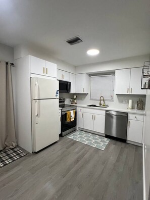A modern kitchen with white cabinets, a refrigerator, a microwave, an oven, and a dishwasher. - Beach Escape 2BR • 5 min FLL • Free Parking (Dania Beach)