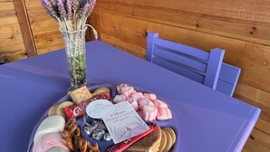 A table with a variety of snacks and a card, set against a wooden wall with a sign reading "Rincón de L'arte". - Lavender Dream in Glamping Rincón de Lavanda (Texcoco de Mora)