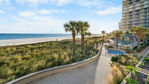 A beachfront hotel with a pool, palm trees, and a view of the ocean. - Bluewater 103 | Beach Front (Orange Beach)