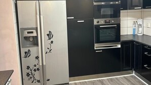 Una cocina moderna con refrigerador, horno y microondas incorporados.