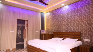 Quarto de hotel com cama de madeira, ventoinha no teto e papel de parede estampado.