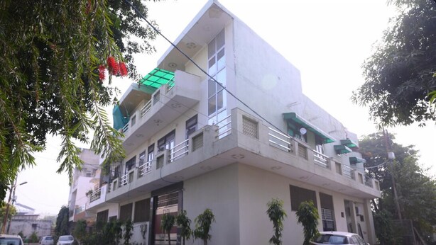 Um edifício de dois andares com telhado plano e varanda no andar superior.