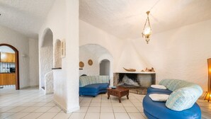 A living room with a fireplace, blue sofa, and a wooden coffee table.