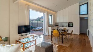 A modern apartment with a living room, dining area, and kitchen.