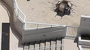 Una piscina con forma singular, rodeada de sillas de descanso y una mesita.
