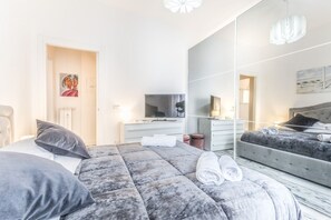 A modern hotel room with a large bed, a television, a mirror, and a desk. - Asinari Retreat [San Marzano] (Roma)
