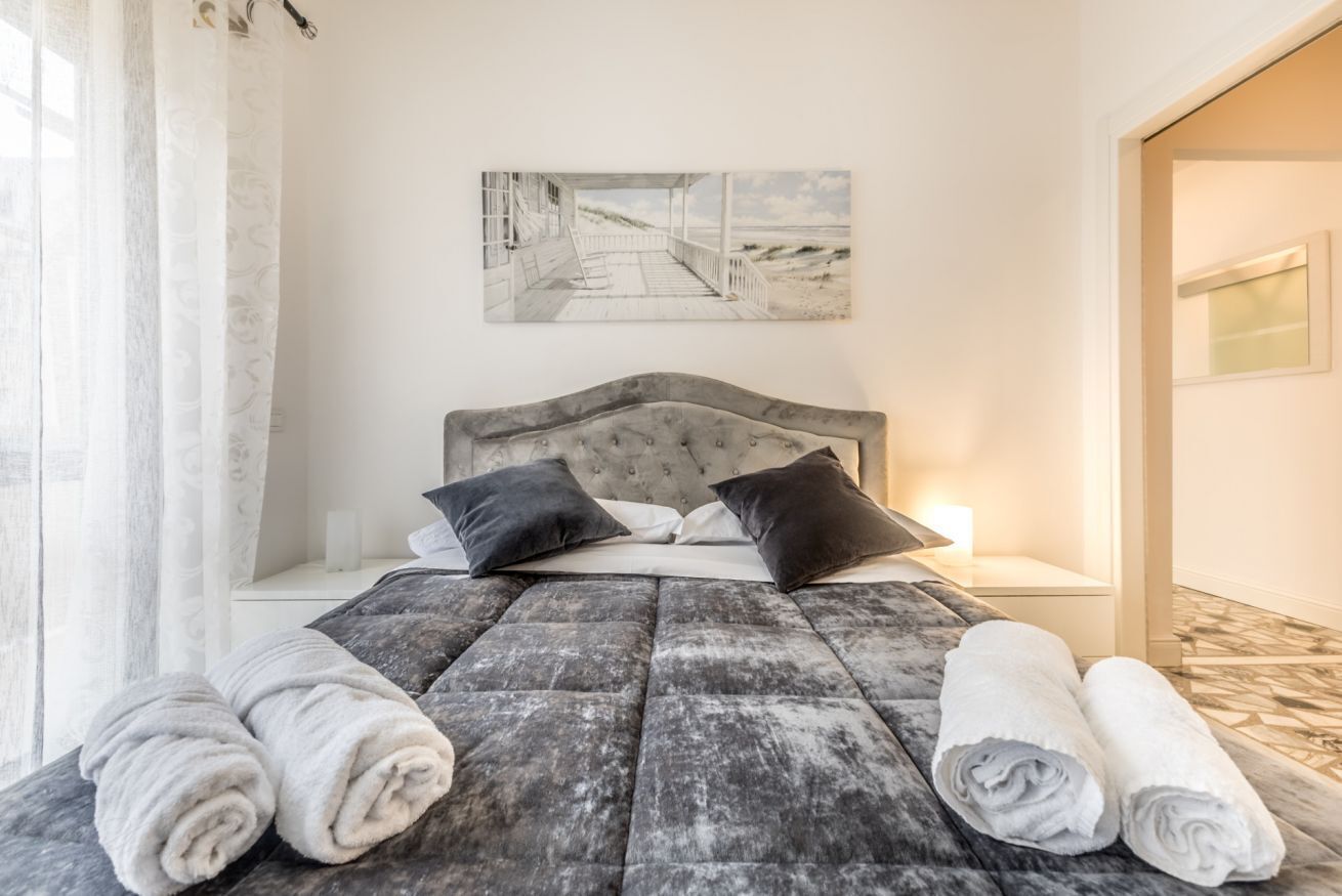 Une chambre à coucher avec un grand lit, deux oreillers, une tête de lit et un tableau accroché au mur.