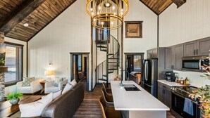 Un salón espacioso con un sofá grande, una mesa de comedor y una cocina con electrodomésticos modernos.