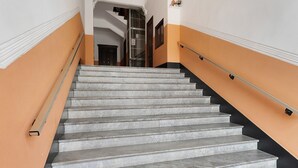 Eine Treppe mit Marmorstufen und Geländer, die zu einer oberen Etage führt.