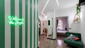 Ein modernes Interieur mit einer Neonreklame, einem grünen Sofa und einem zur Kammer führenden Gang.