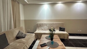 Un salon moderne avec un canapé, une table basse et une petite table d’appoint.