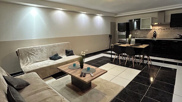 Un salon moderne avec un canapé, une table basse et un coin repas.