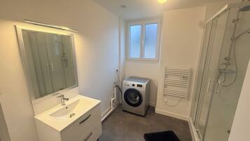 Een haardroger, handdoeken, zeep, toiletpapier