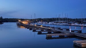 A marina with boats docked, calm water, and a dock extending into the water. - Cozy Pickwick Lake house overlooking Safe Harbor Aqua Yacht Marina Sleeps 10+ (Iuka)