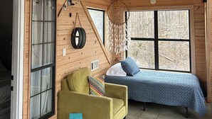 A cozy cabin with a wooden interior, a bed, a sofa, and a ceiling fan. - Cozy Pickwick Lake house overlooking Safe Harbor Aqua Yacht Marina Sleeps 10+ (Iuka)