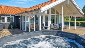 Een modern huis met een zwembad, buiten zitplaatsen en een overdekt terras.