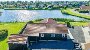 Een woonwijk met een huis, voorzien van een pannendak, een kleine aangebouwde garage en een verharde oprit.