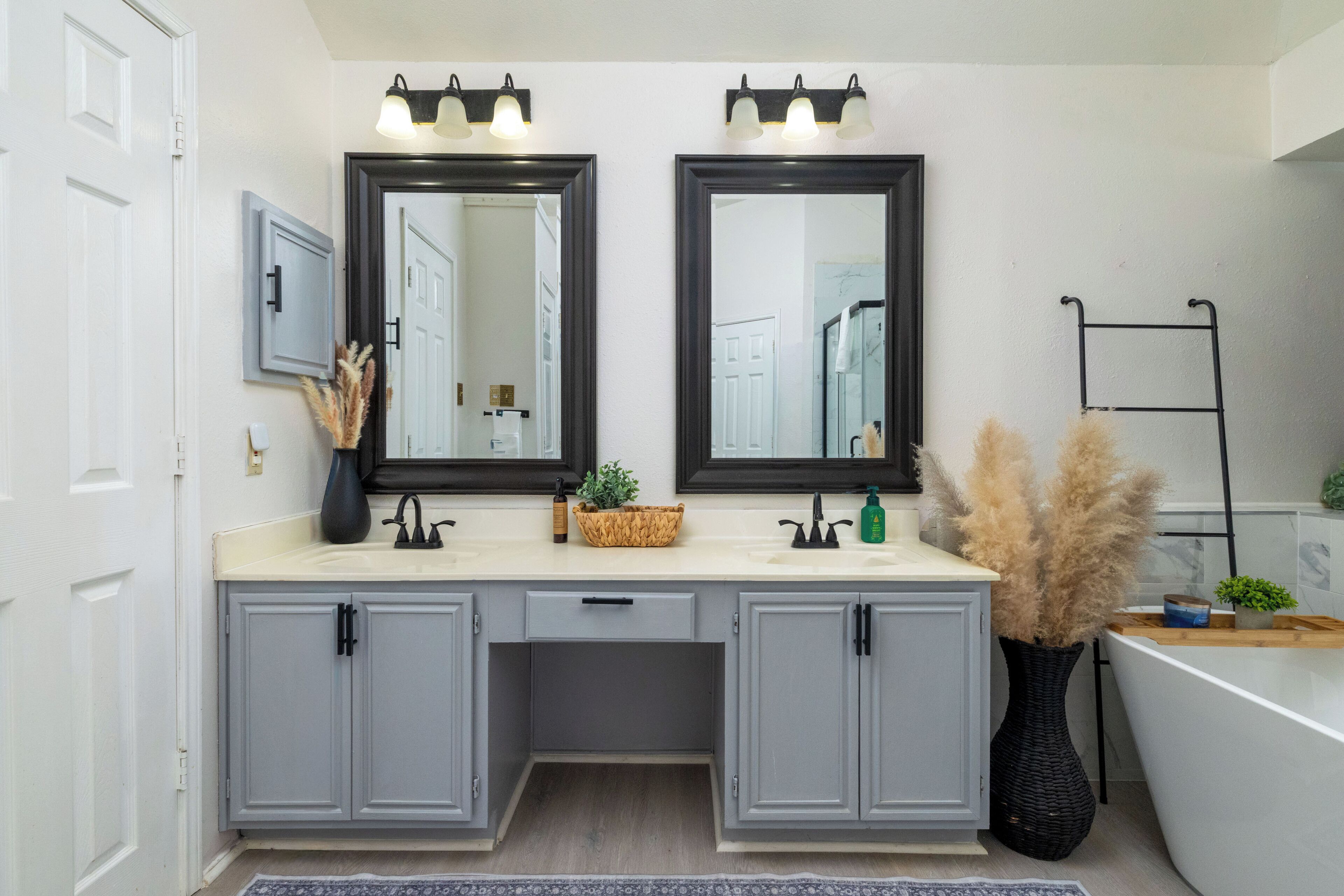 Une salle de bain avec deux miroirs, un lavabo et une baignoire.
