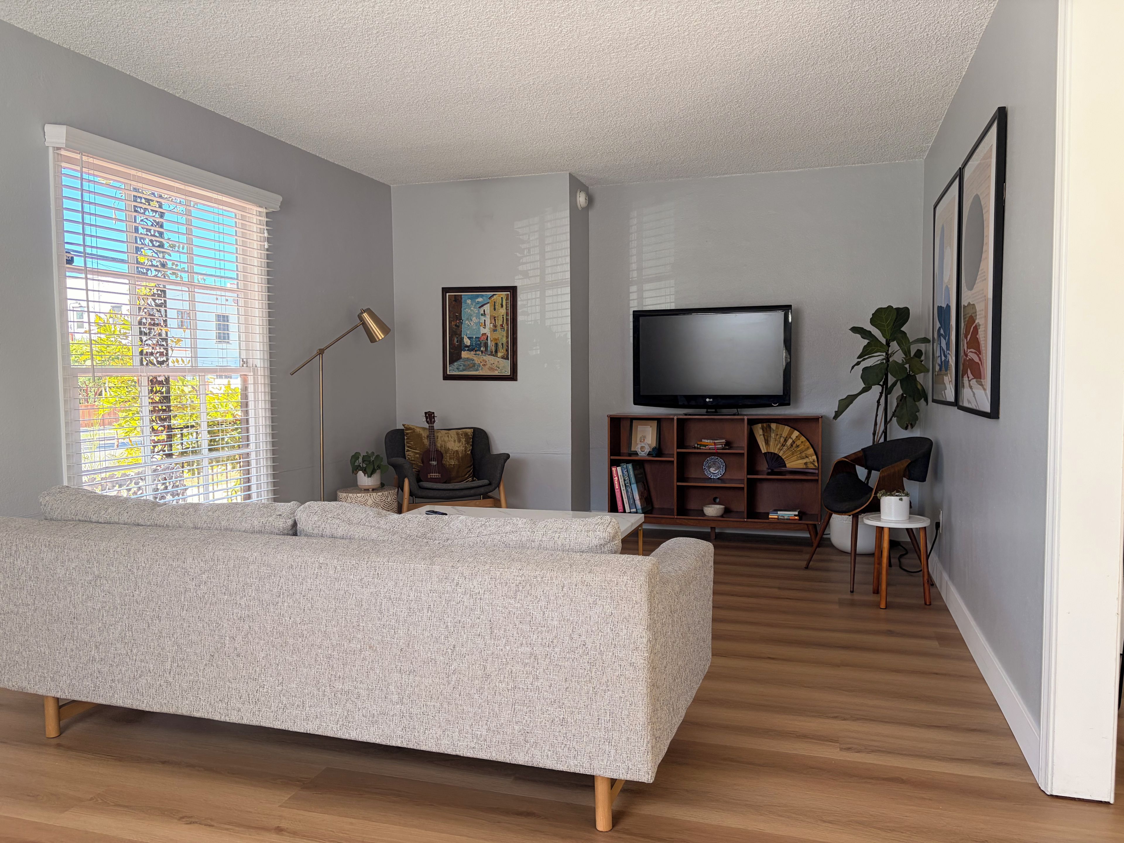 Una sala moderna con un sofá, televisión y estantería.