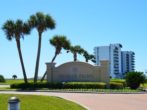 A sign for 'Palisade Palms' with a clear sky and palm trees. - Palisades Palms Tw1012 - Sea Escape (Galveston)
