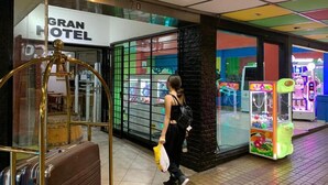 A hotel entrance with a sign reading "GRAN HOTEL" and a luggage stand. - Gran Hotel Turismo (Mendoza)