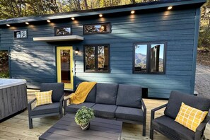Une cabane moderne à deux étages, dotée d’une terrasse, d’un espace salon extérieur et d’un bain à remous.