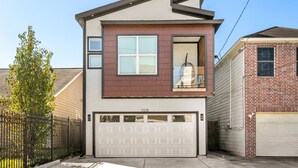 A modern two-story house with a garage, a large window, and a visible balcony. - Downtown Houston escape with en-suites (Houston)