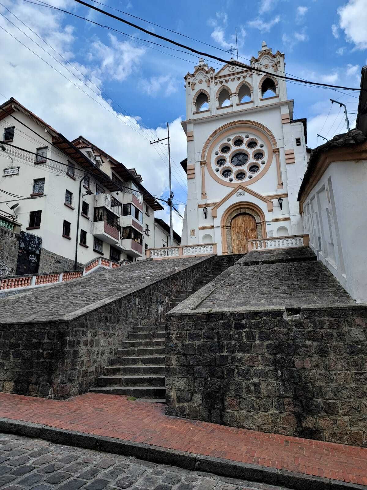 A church with a large circular window and a bell tower.