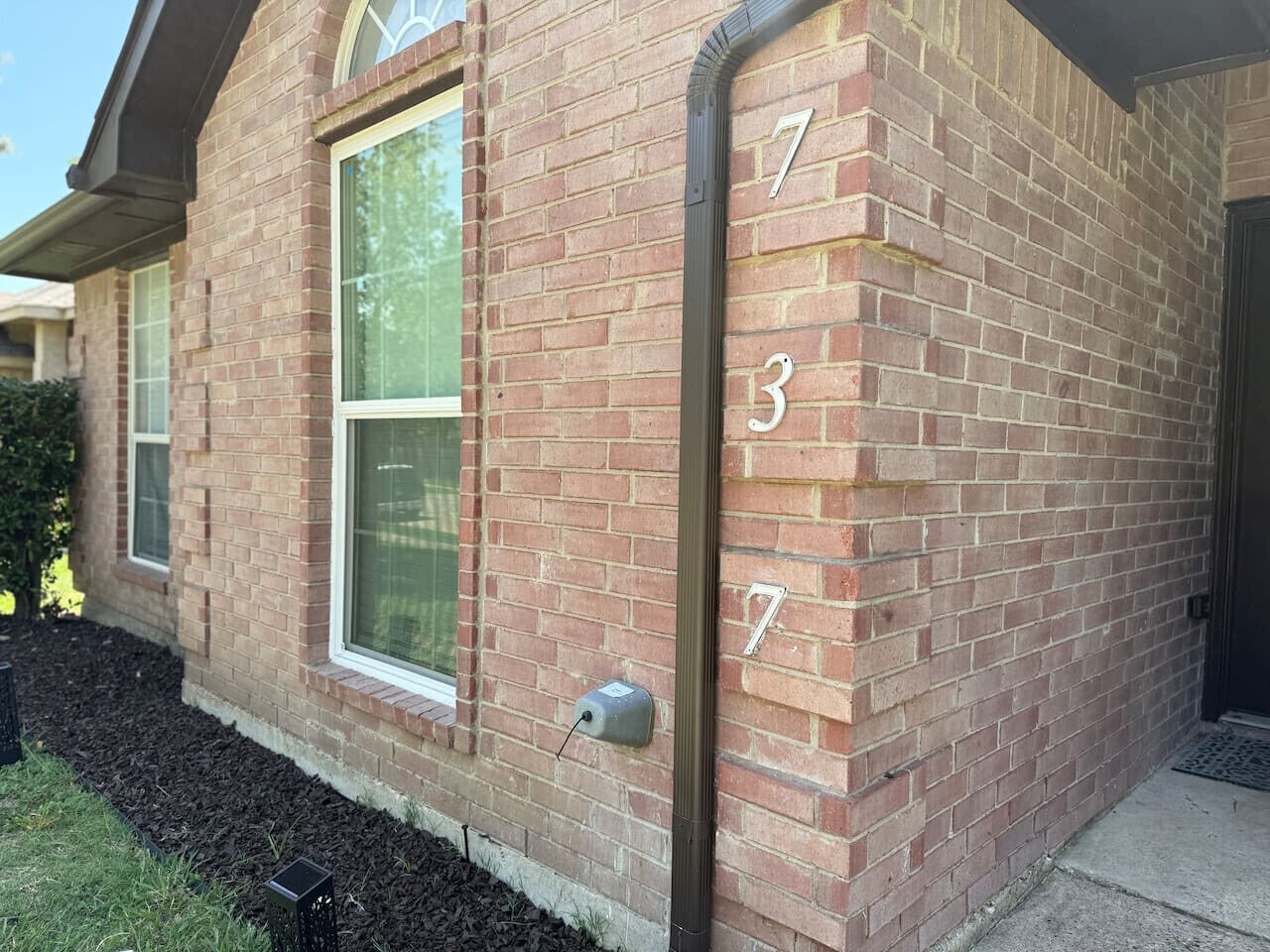 Une maison en briques avec le numéro 737 sur le côté.