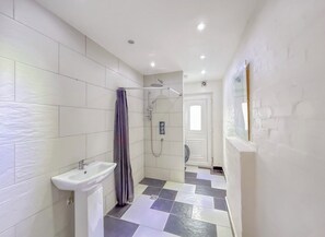 Een douche, handdoeken, zeep, toiletpapier