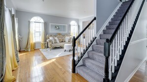 A spacious living room with a staircase. - 'The Mirror' - Elegant & Dog-Friendly DMV Home (Upper Marlboro)