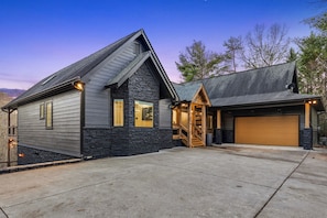A two-story house with a stone facade, a garage, and a staircase leading to the second floor. - Mtn Views + Theater + Hot Tub | 5 King Suites (Blue Ridge)