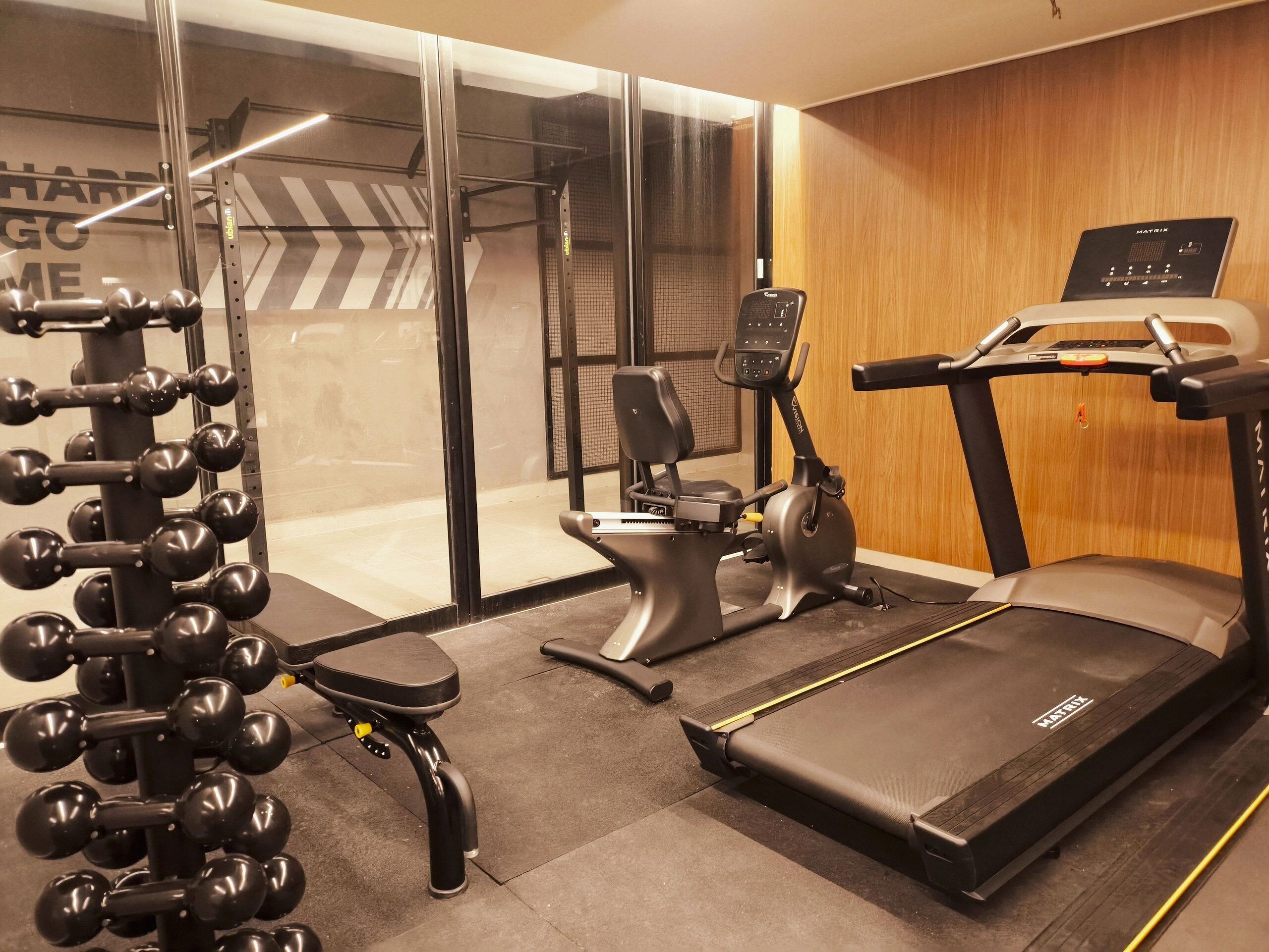 A home gym with a treadmill, elliptical, and weight machine.
