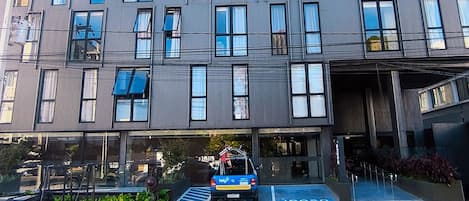A multi-story building with a modern architectural design, featuring large windows and a flat roof.
