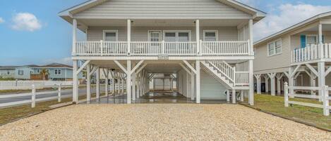 A two-story building with a balcony and a covered walkway.