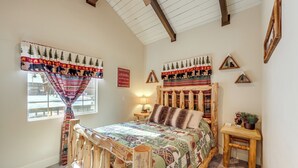 A cozy bedroom with a wooden bed frame, a patterned quilt, and a window with a view of the outside. - < 1 Mi to Bear Mtn! Family Ski Cabin w/ Game Room (Big Bear Lake)