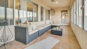 A sunlit patio with a sofa, a coffee table, and a ceiling fan. - Golf, Fish & More! Peaceful Home in Helendale (Helendale)