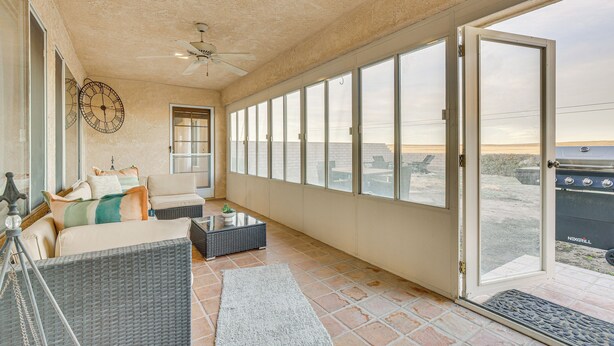 A spacious balcony with a sofa, a coffee table, and a grill. - Golf, Fish & More! Peaceful Home in Helendale (Helendale)