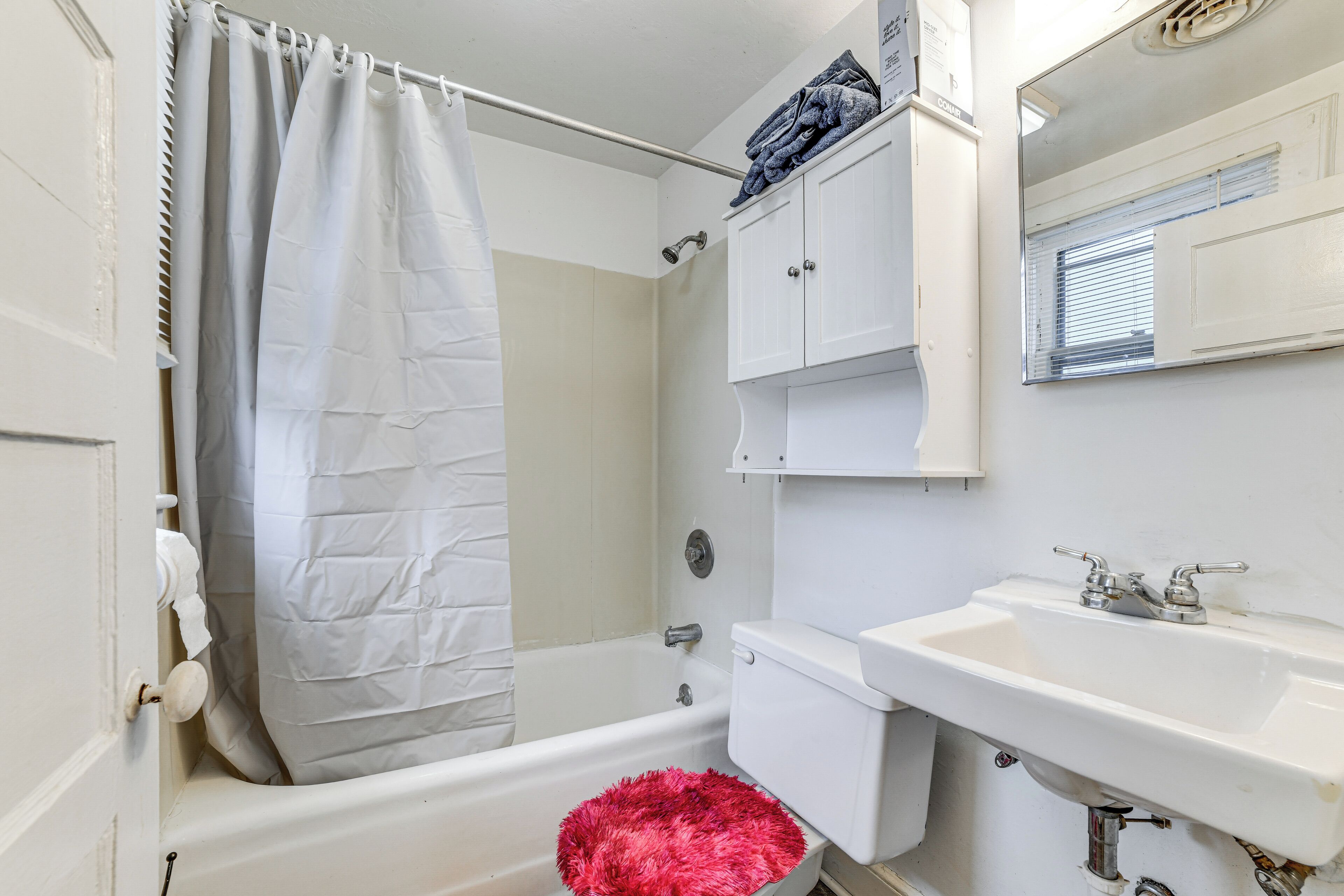 A bathroom with a bathtub, toilet, sink, and a shower curtain.