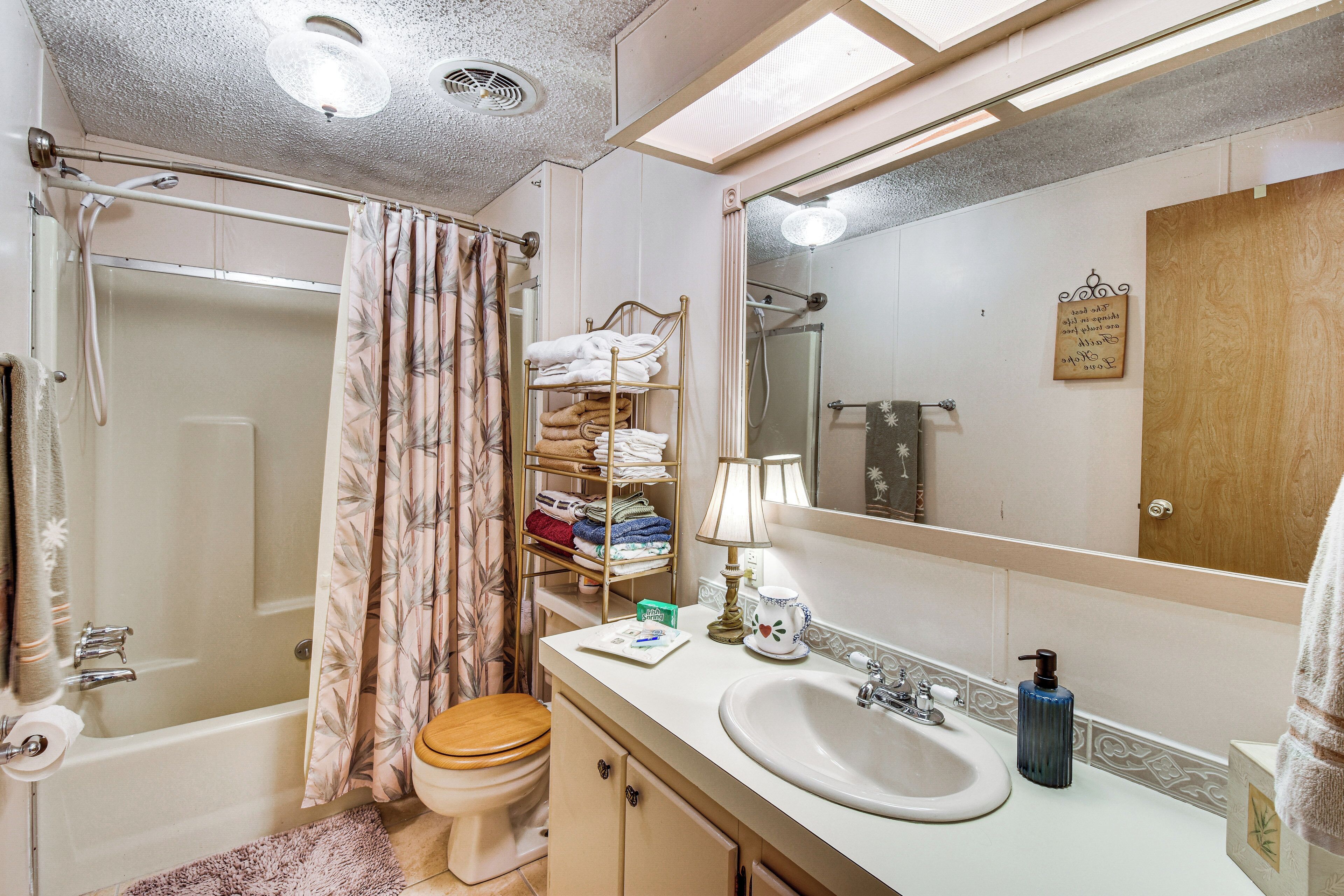 Une salle de bain avec une baignoire, des toilettes, un lavabo et un miroir.