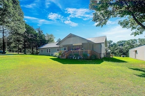 A two-story house with a covered porch and a fenced yard. - Pool, Large Porch! Country Home Near Roaring River (Seligman)