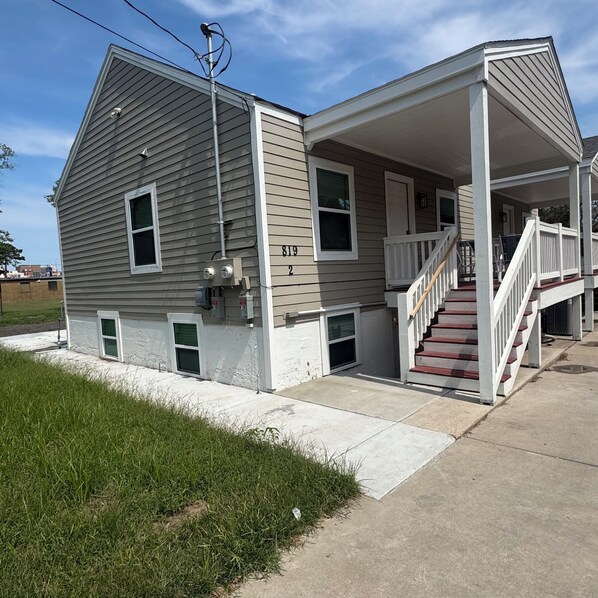 A two-story house with a covered porch and a staircase leading to the second floor.