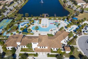 An aerial view of a residential area with a large swimming pool, tennis courts, and a fountain. - 2406 - Great Family Home Near Disney, Pool. (Kissimmee)