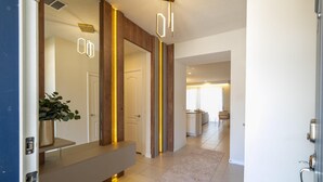 A modern hallway with a bench, a potted plant, and a door. - 2406 - Great Family Home Near Disney, Pool. (Kissimmee)