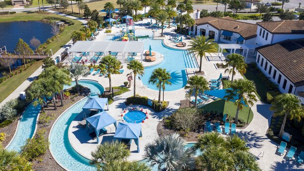 A resort with a large swimming pool, palm trees, and a water slide. - 2406 - Great Family Home Near Disney, Pool. (Kissimmee)