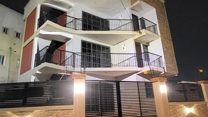 Ένα πολυώροφο κτίριο κατοικιών με μια κεντρική αυλή, μπαλκόνια και μια πύλη στην είσοδο.