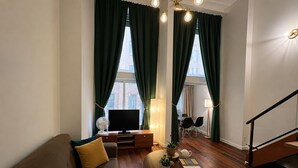Ein modernes Wohnzimmer mit Sofa, Fernseher und Essbereich.