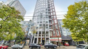Ein mehrstöckiges Gebäude mit modernem architektonischen Design, gekennzeichnet durch eine markante, gebogene Fassade und eine Kombination aus Glas- und Metallelementen.